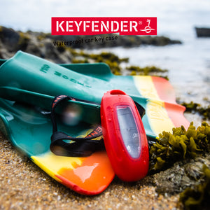 Keyfender liegt am Strand zusammen mit Surf Equipment